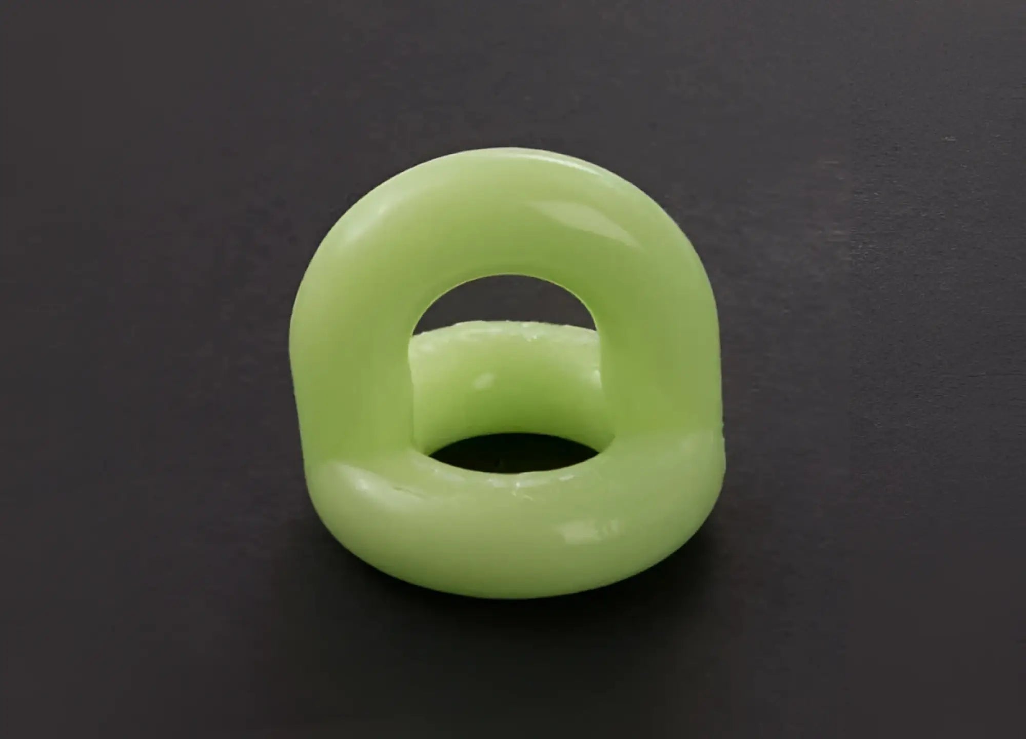A smooth light green silicone sport f-cker tpr c ring glow with a glossy finish and open center size one size