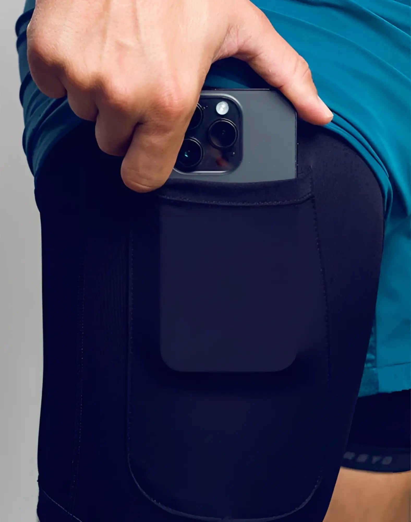 Black spr flex short athletic legging with built-in pocket holding a dark gray smartphone