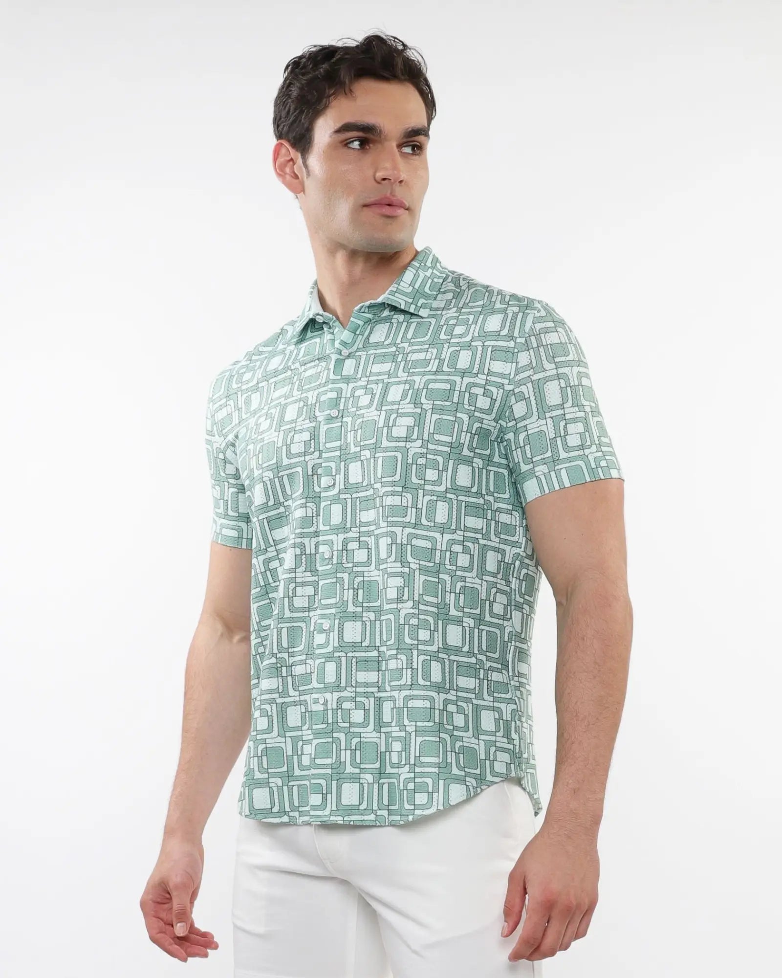 A man wearing a short-sleeved light green and white squares print open knit polo shirt with geometric pattern