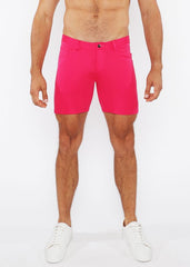 Bright pink stretch knit shorts for men with a clean tailored fit and single button closure