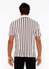 A man wearing a vertical stripe open stretch knit shirt with rib collar in black and off-white textured fabric