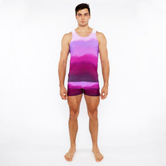 A man wearing a gradient purple and pink tie-dye tank top with matching gradient printed swim shorts