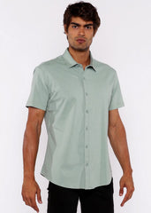 A man wearing a light green stretch knit shirt with short sleeves and a classic collar in neatly pressed fabric