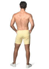 Light yellow stretch knit shorts with a clean tailored fit and two back pockets shown from the back side
