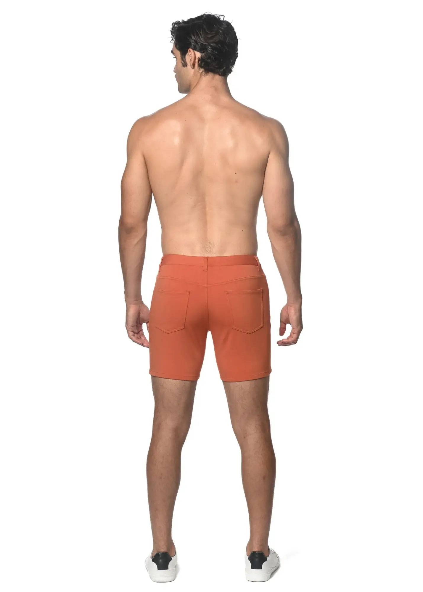 Back side of orange stretch knit shorts with two pockets and a tailored, clean fit in breathable fabric