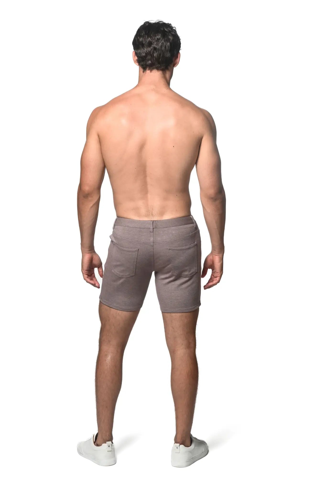 A pair of taupe stretch knit shorts for men with a relaxed fit and two back pockets shown from the back side