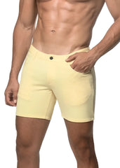 A pair of pale yellow stretch knit shorts with a classic button closure and side pockets in a form-fitting style