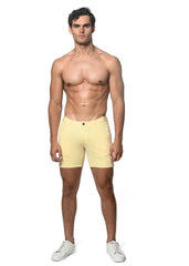 A pair of pale yellow stretch knit shorts with form-fitting design single button closure and belt loops