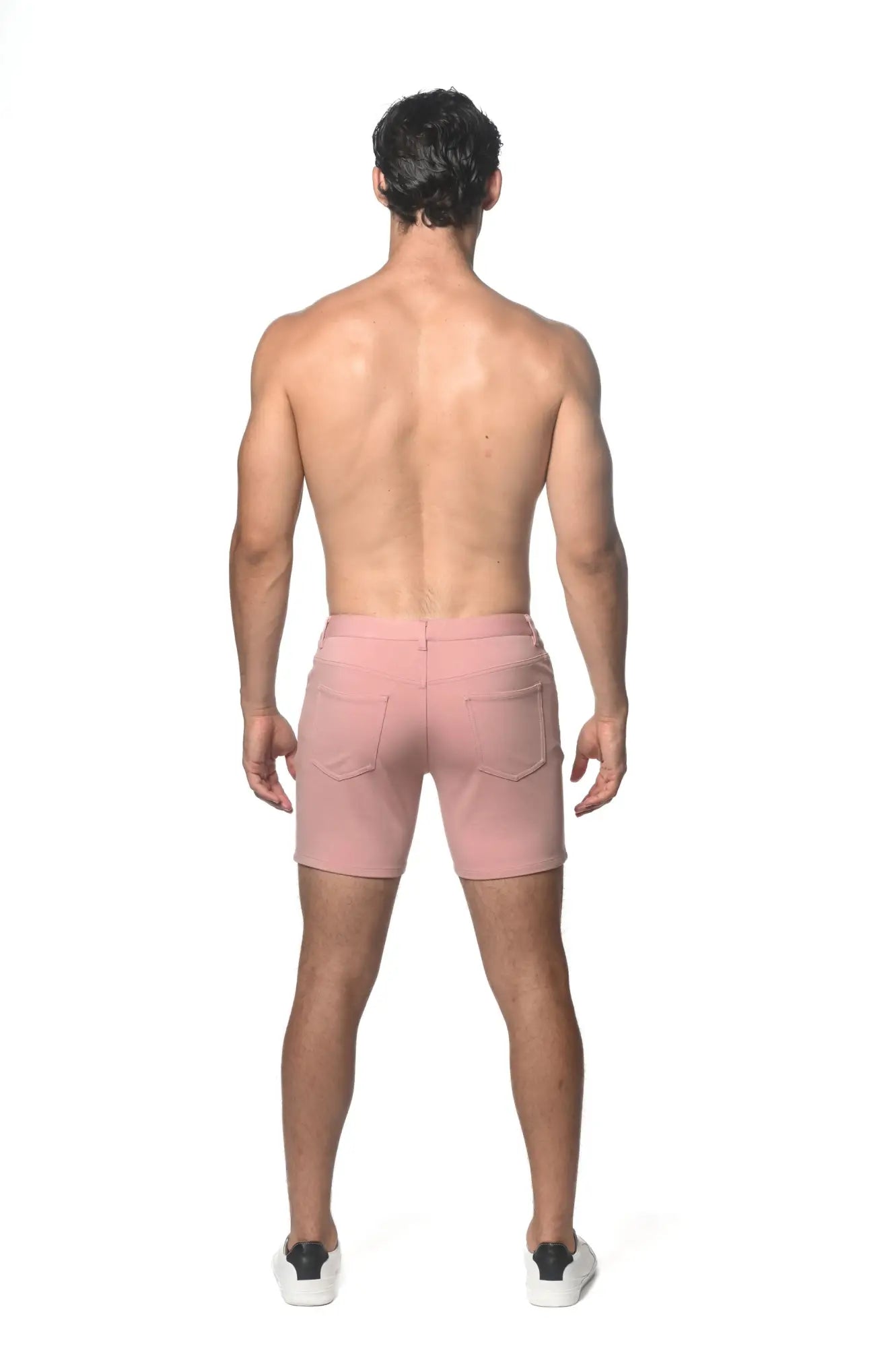 Pink stretch knit shorts with two back pockets and zipper closure shown from the back side