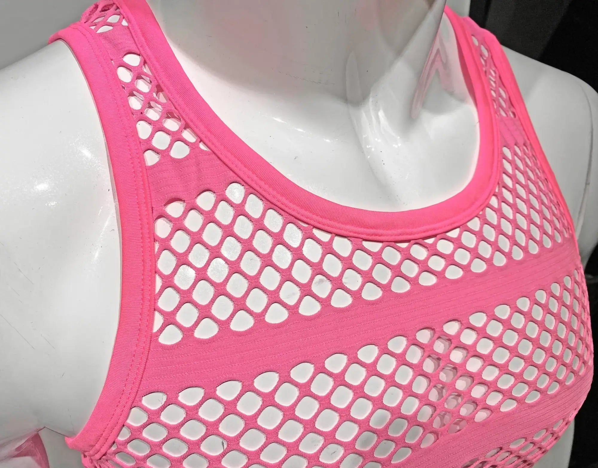 Bright pink striped fishnet tank top with mesh material and rounded neckline in a fitted design