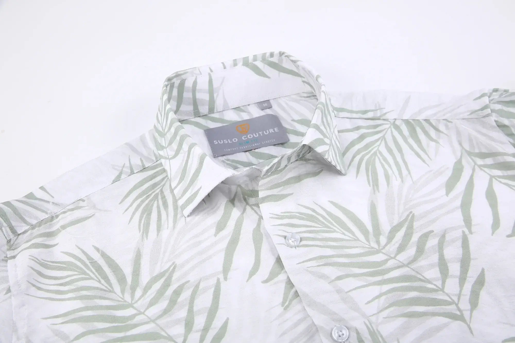 White button-down summer rain s/s shirt with subtle green palm leaf pattern and suslo couture label at the collar