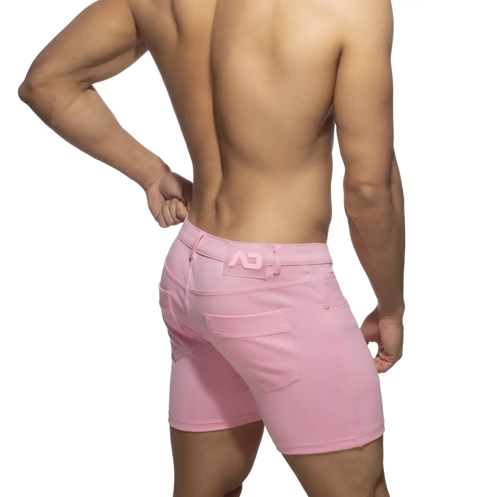 Pink denim svelte shorts with a subtle logo on the waistband shown from the back side