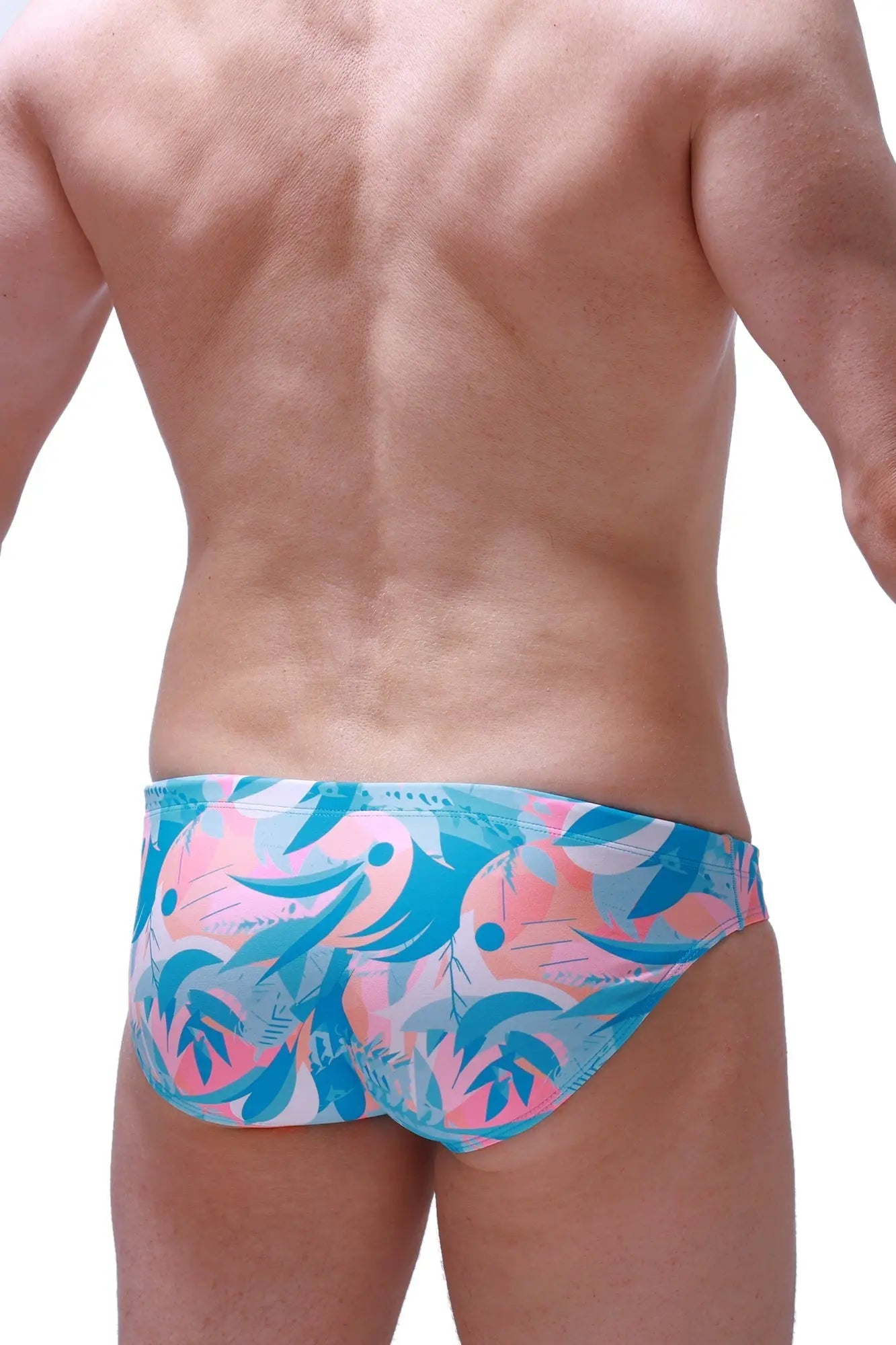 Swim brief nant boucan featuring vibrant tropical-patterned swim trunks in pink and teal with bold abstract design