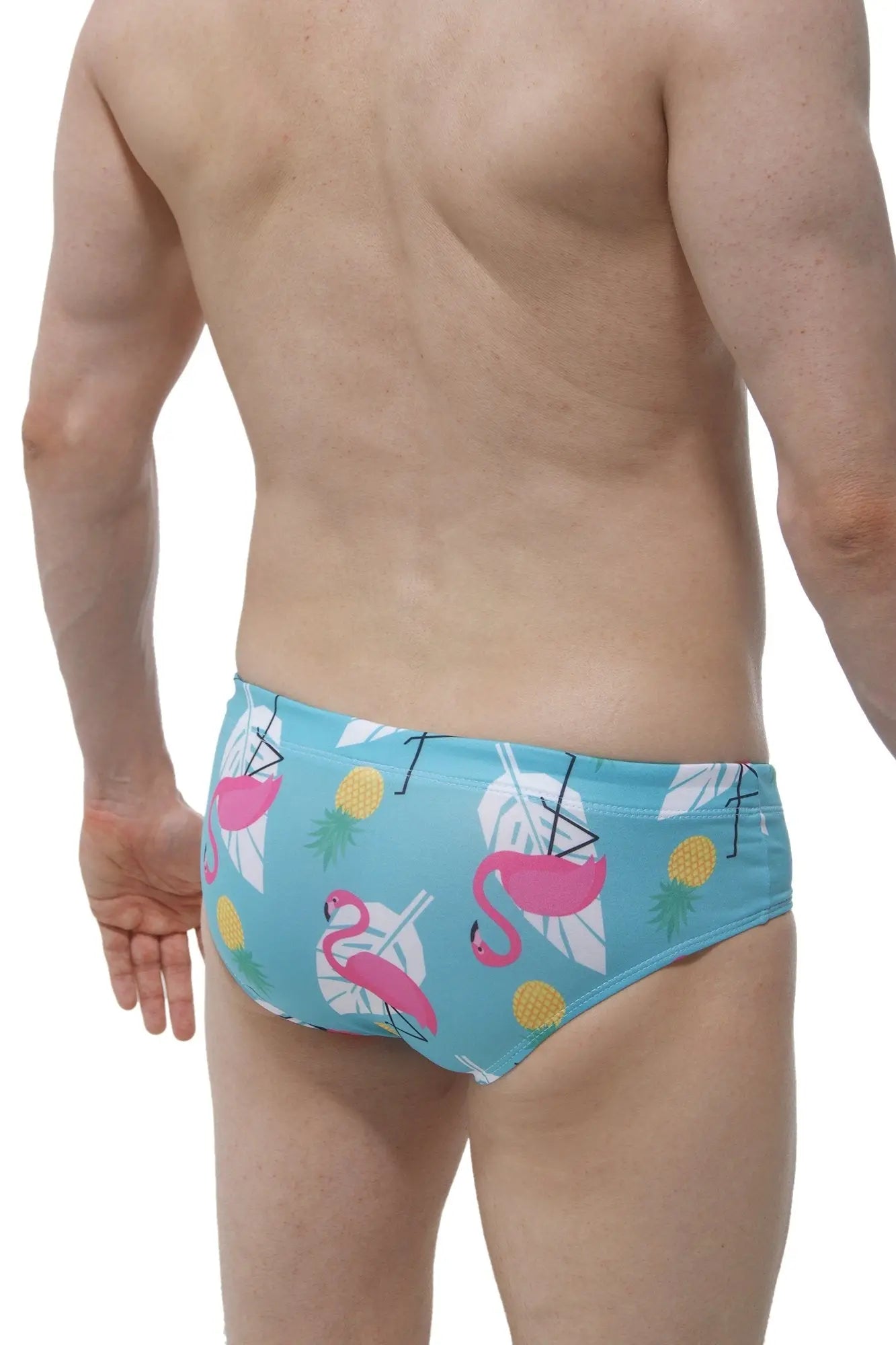 Light blue swim brief pina colada with male cup pad featuring pink flamingos white tropical leaves and yellow pineapples