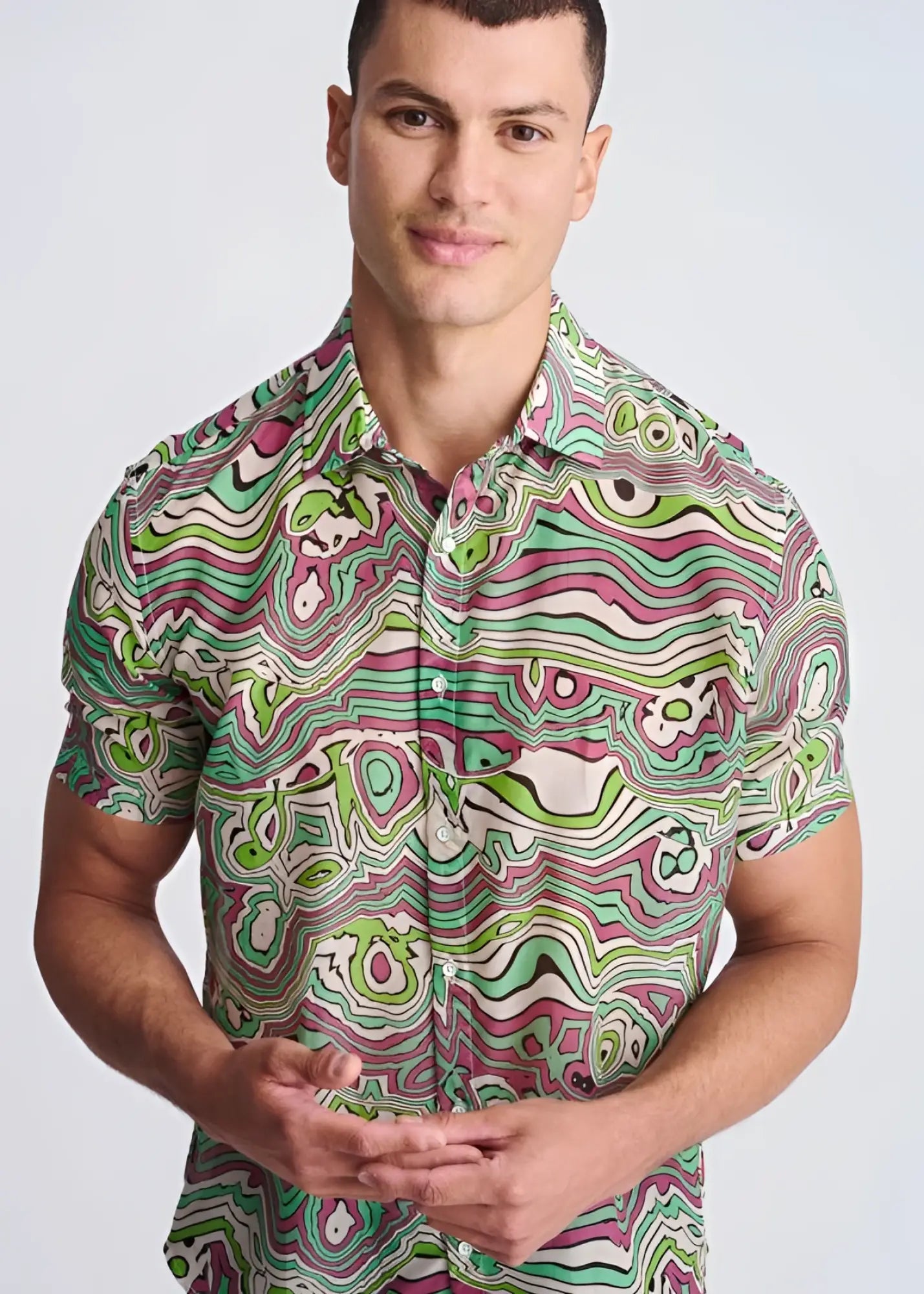 A vibrant short-sleeved button-up swirls lightweight cotton silk shirt with green pink and white psychedelic patterns