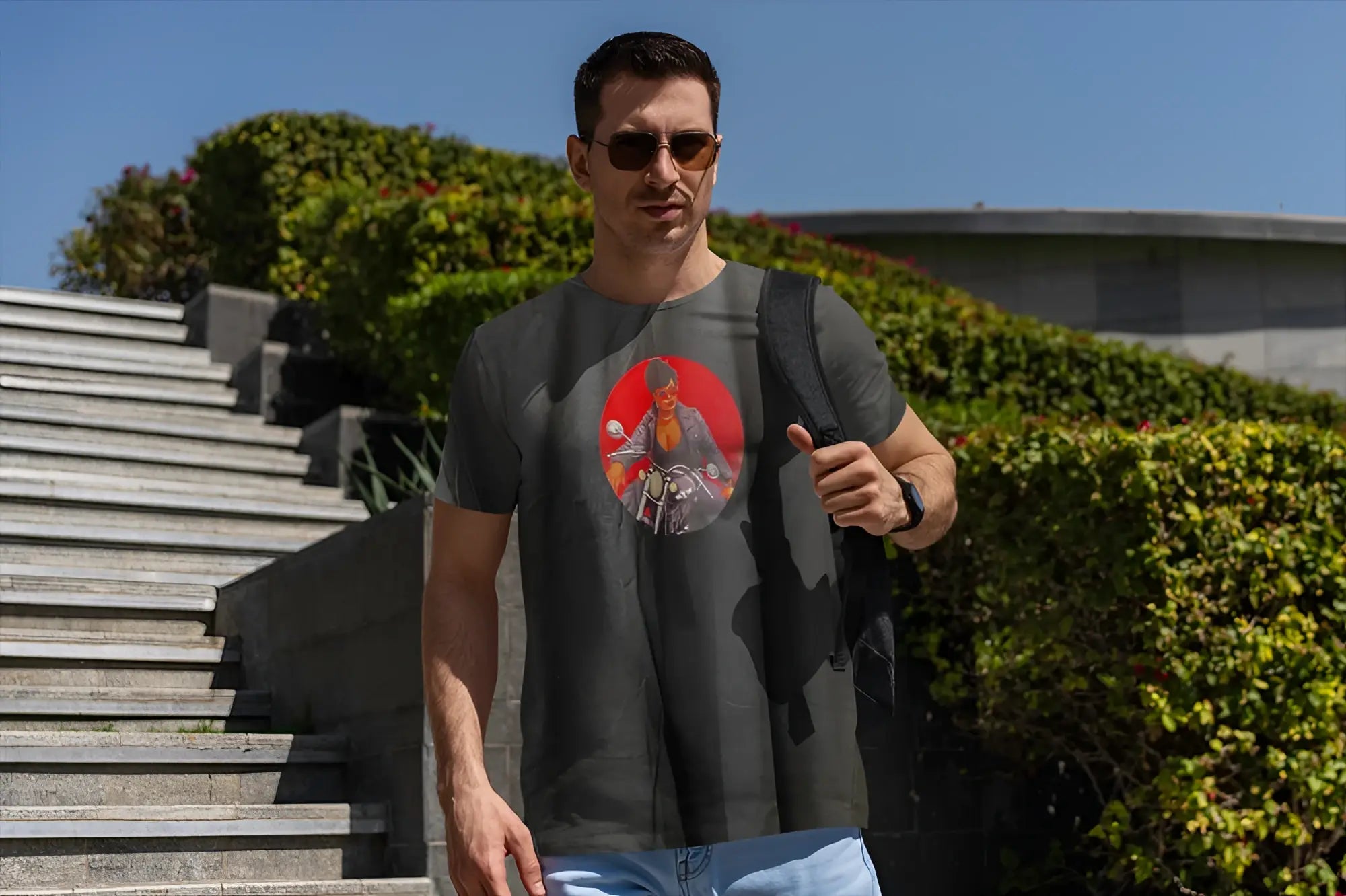 Dark gray short-sleeved t-shirt featuring a circular graphic of a man on a motorcycle against a red background