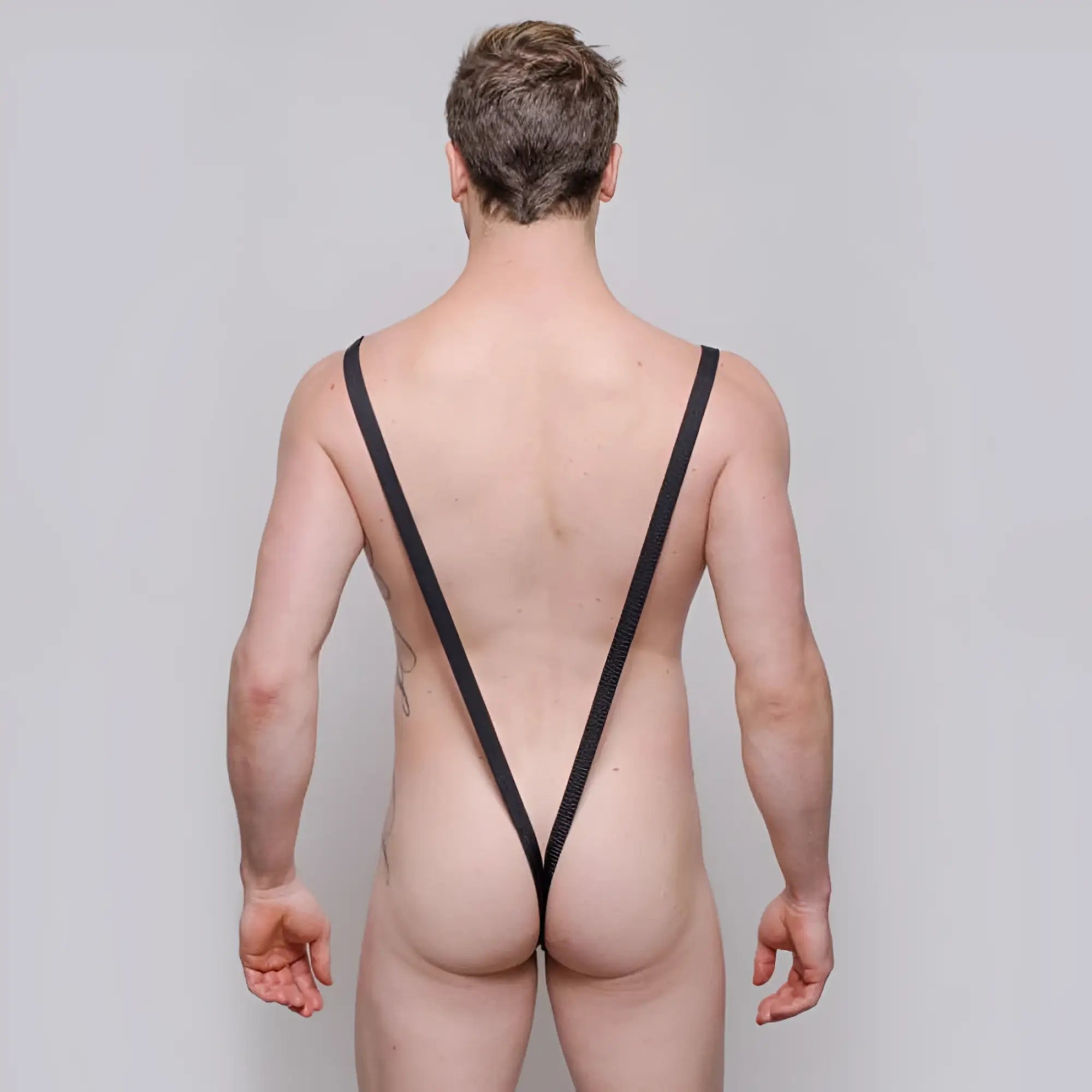 Black mesh strappy backless briefs showing the back of the Tartarus sling shot body thong with rings