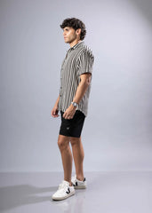 A man wearing a black and white vertically striped texture knit short-sleeved shirt perfect for casual wear