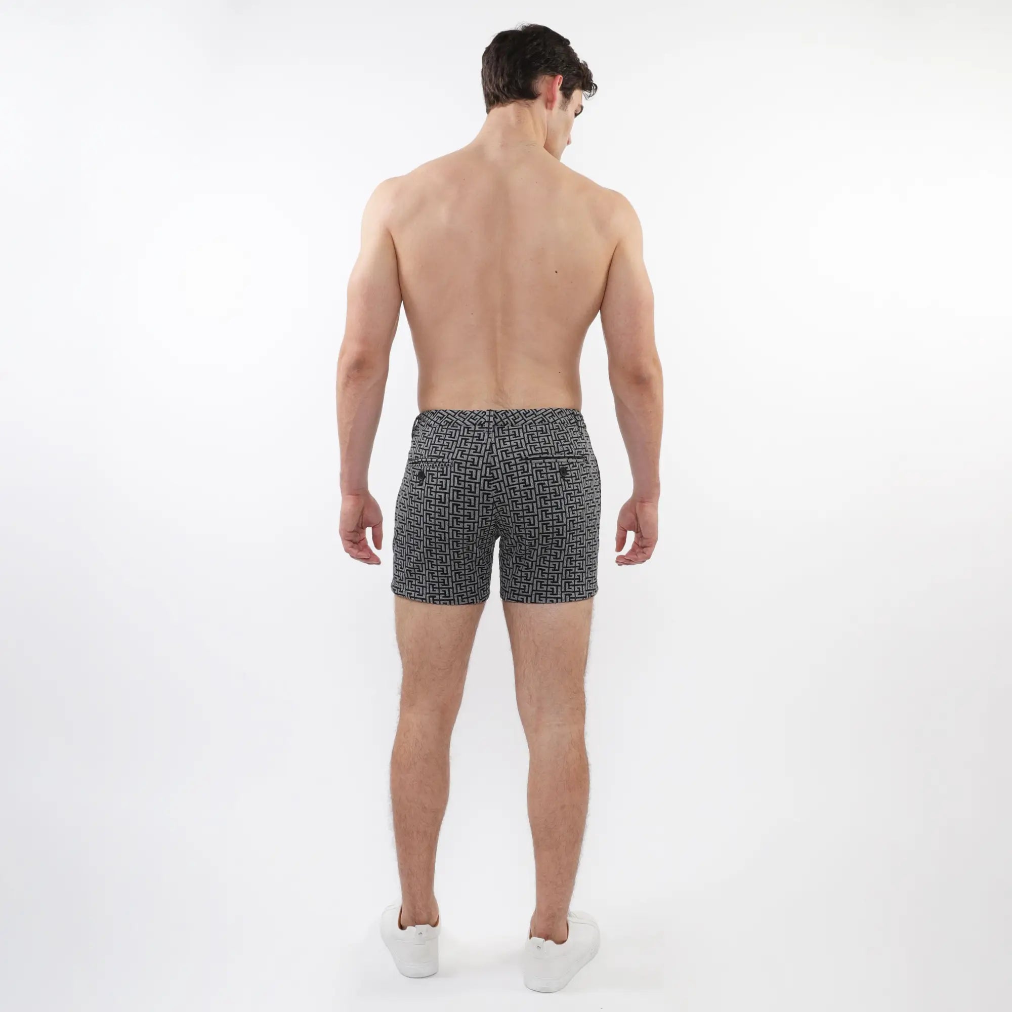 Black and white geometric-patterned textured jacquard stretch knit chino shorts with zip pockets shown from the back
