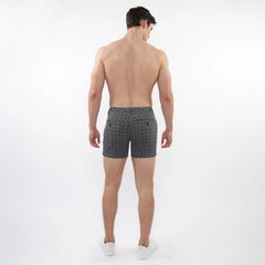 Black and white geometric-patterned textured jacquard stretch knit chino shorts with zip pockets shown from the back