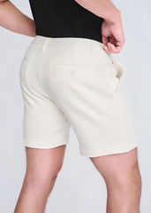 Cream-colored textured stretch knit chino shorts showing the back with a small buttoned pocket and tailored fit