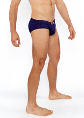 Navy blue textured swim brief with front buckle and metallic logo on waistband designed for stylish swimming
