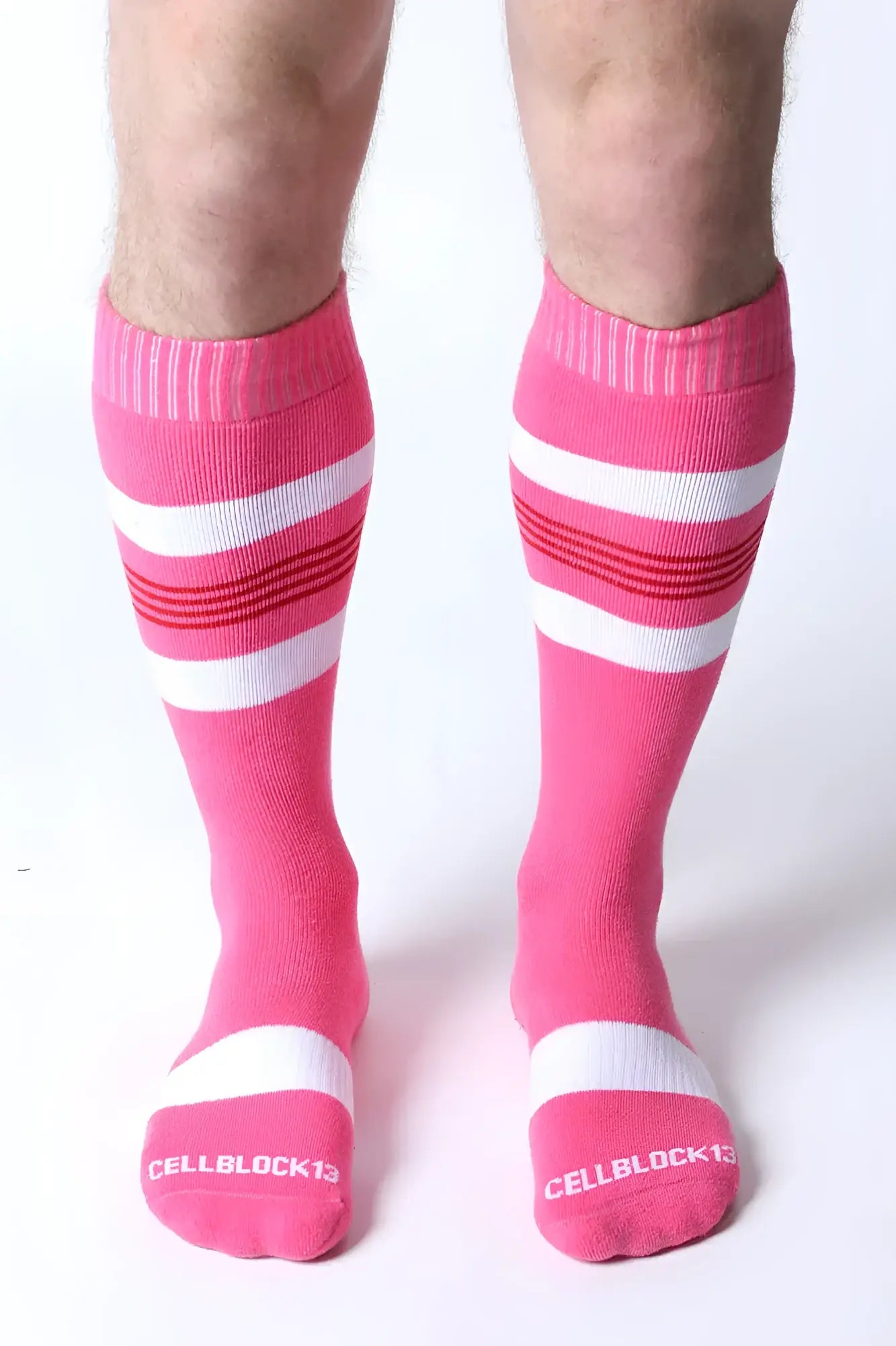 Bright pink tight end knee high socks with white and red stripes and cellblock13 logo on the toe