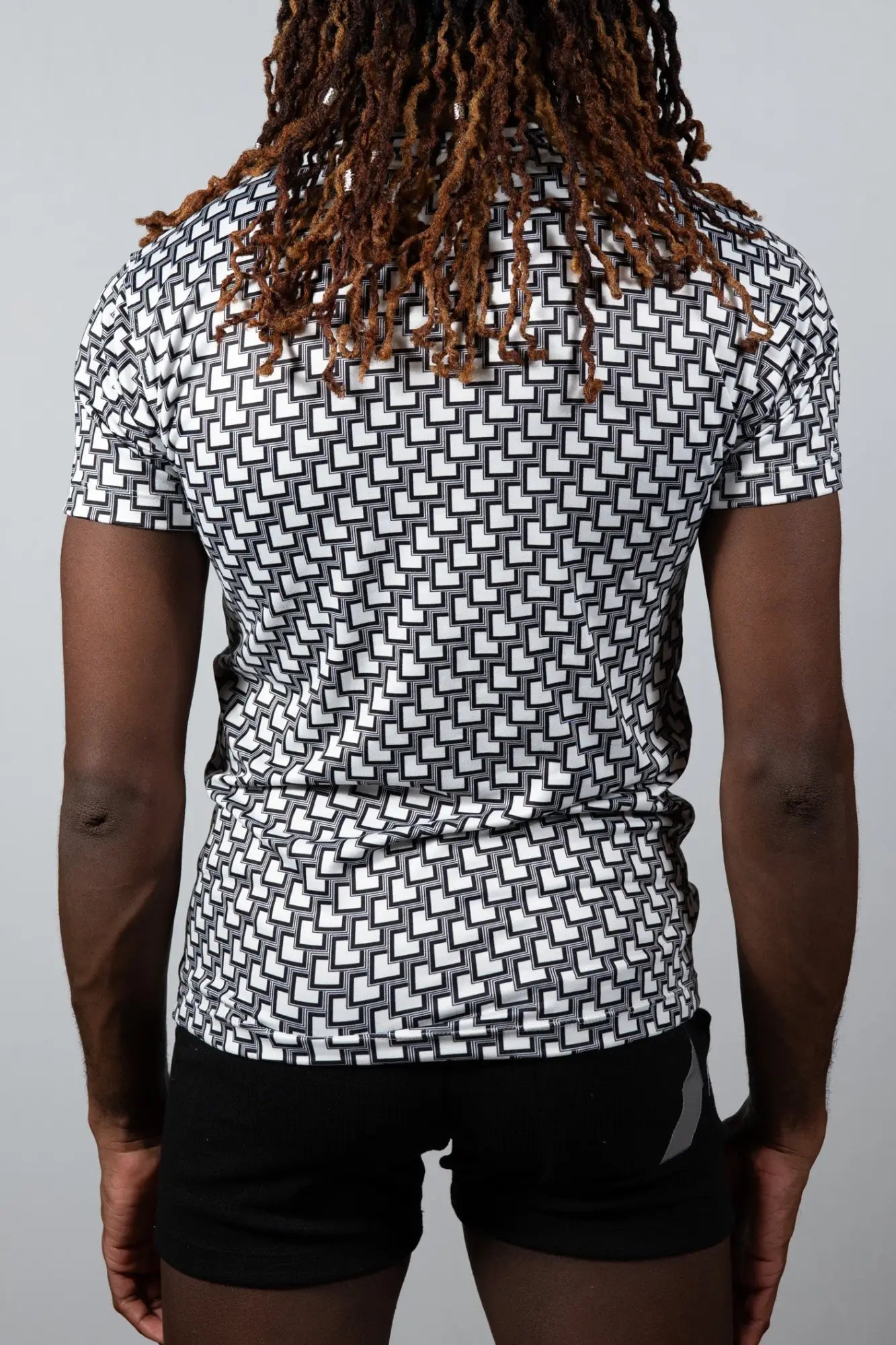 Black and white geometric-patterned short-sleeve athletic shirt made from breathable fabric for active wear
