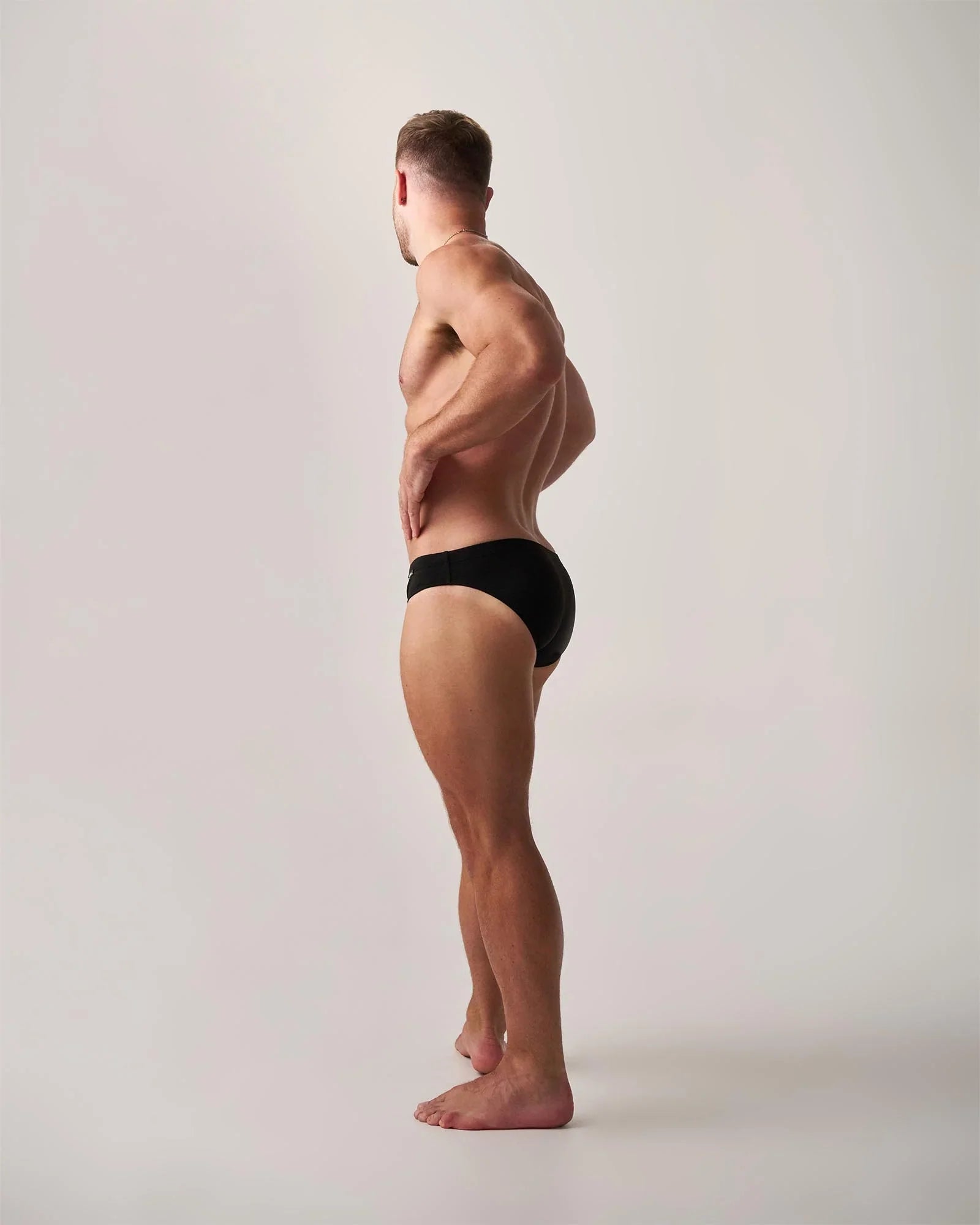Black statement swim brief made of lightweight fabric showing the front view