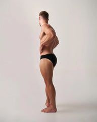 Black statement swim brief made of lightweight fabric showing the front view