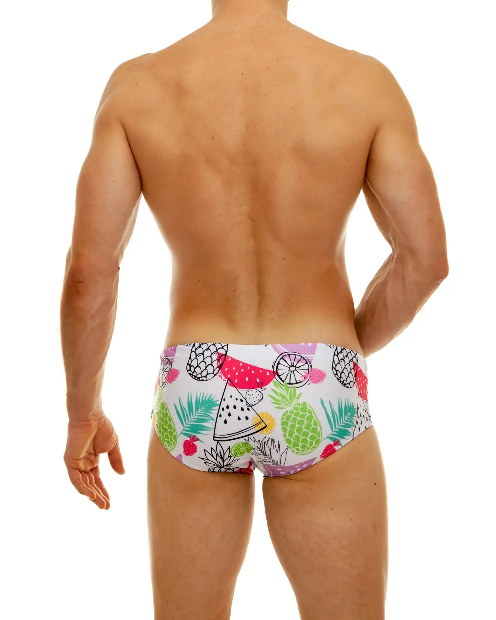 Tropical fruit swim brief white swim trunks with vibrant pink green yellow and black tropical fruit pattern