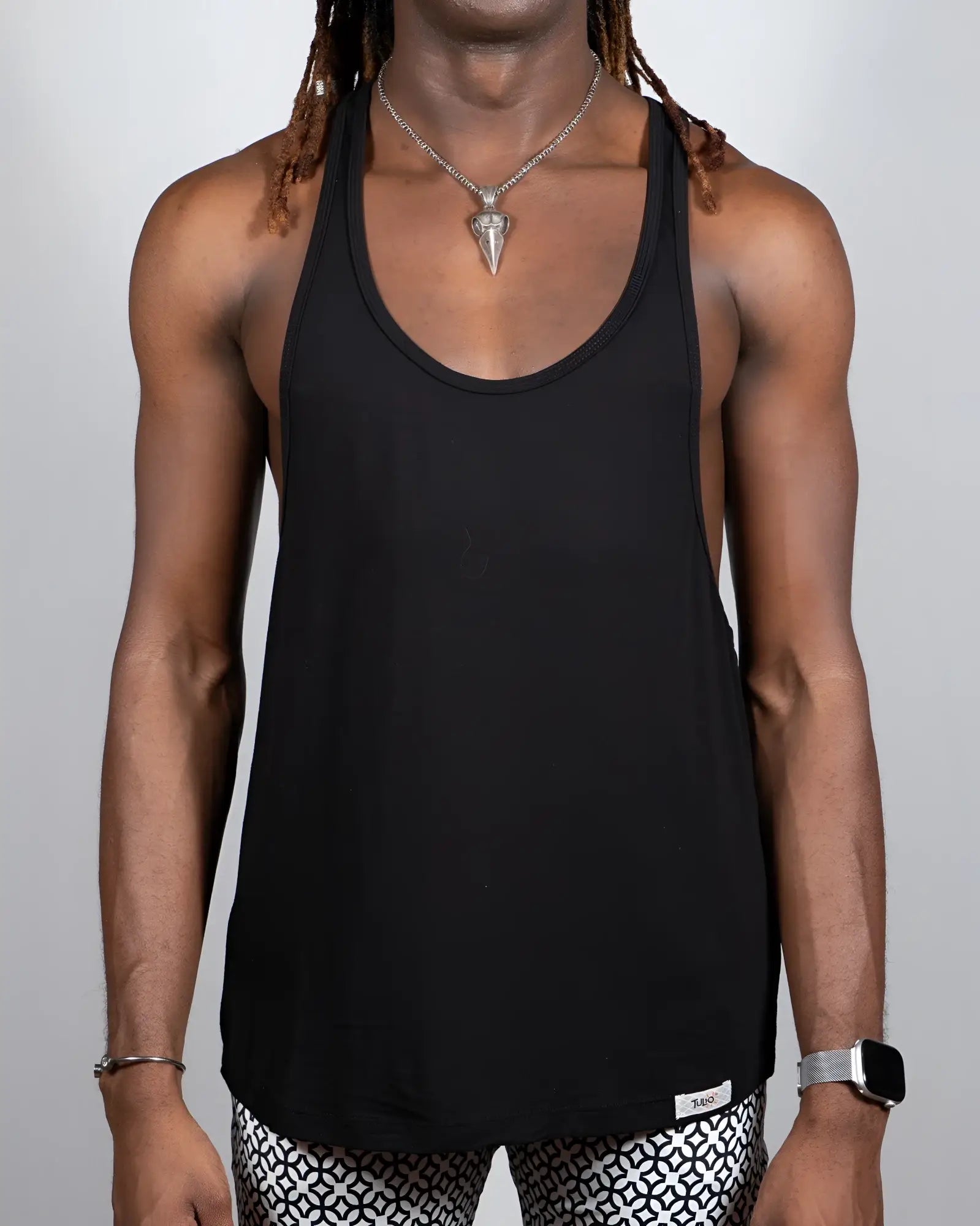 Black tulio racerback tank top with minimalist design and small brand tag at bottom hem in four colors available
