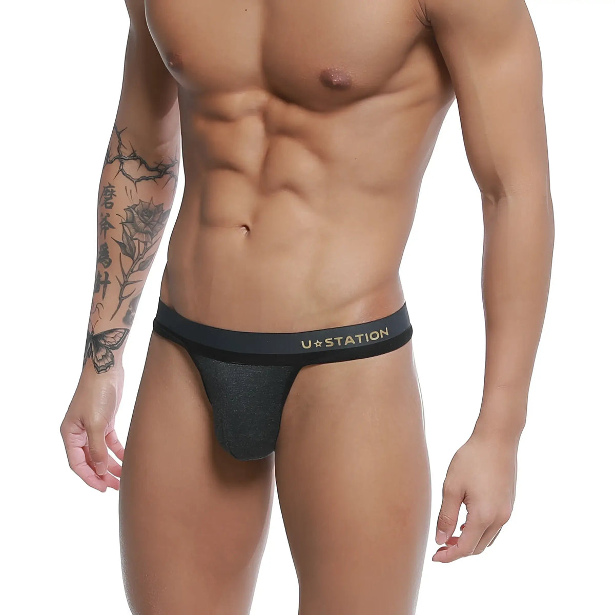 Black ustation talent thong with subtle heathered texture and gold lettering on the waistband front side