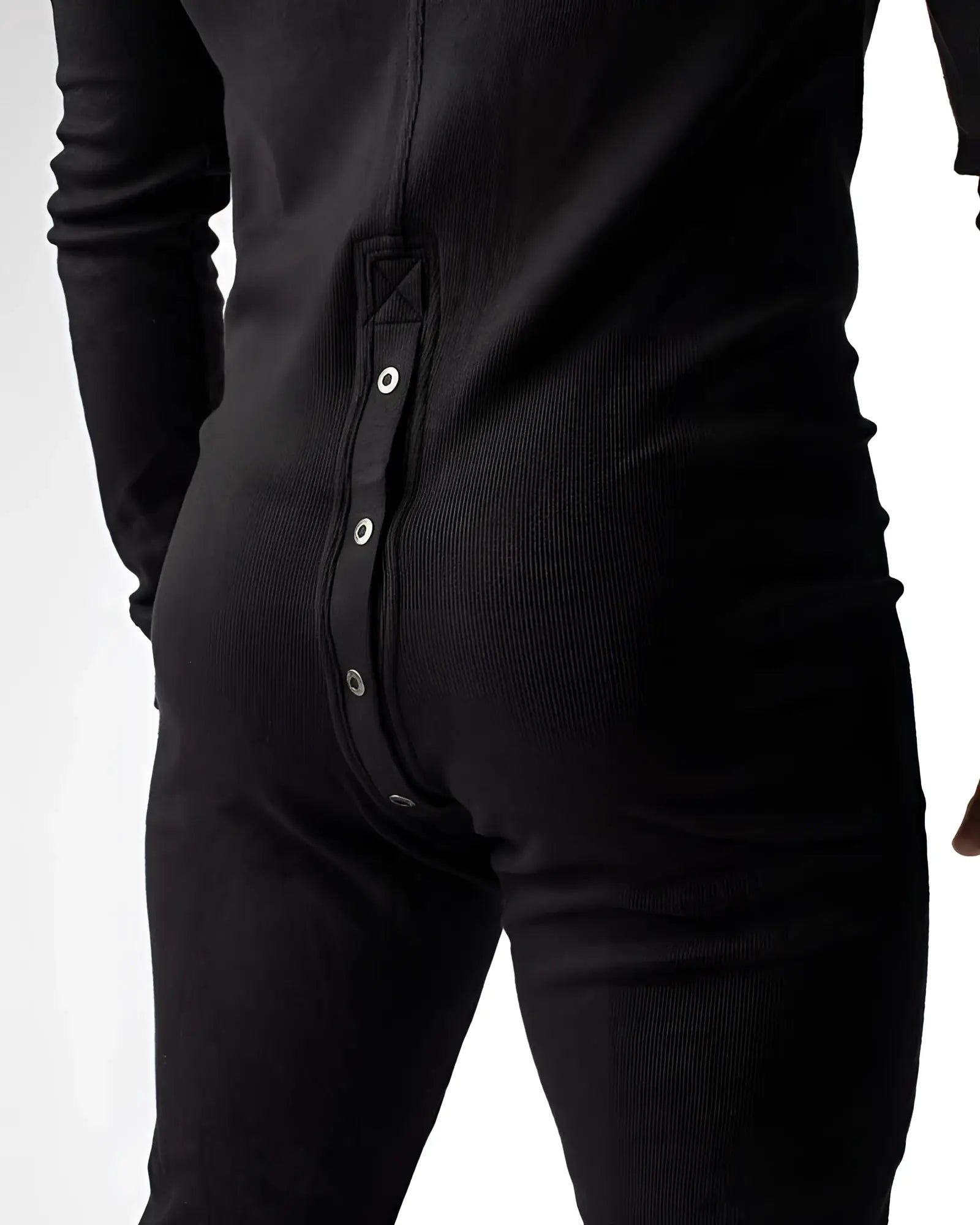 Black ribbed knit union suit one-piece pajama shown from the back with vertical row of silver snap buttons
