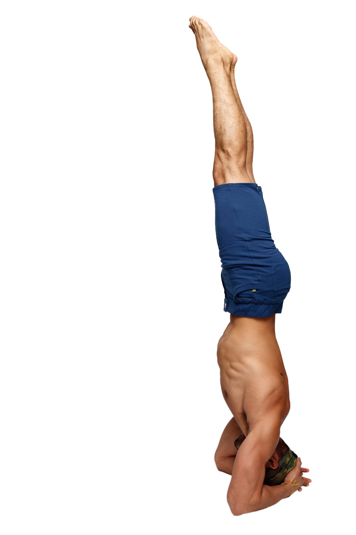 A muscular man performing a headstand wearing royal blue urban tactical at home dress shorts designed for comfort