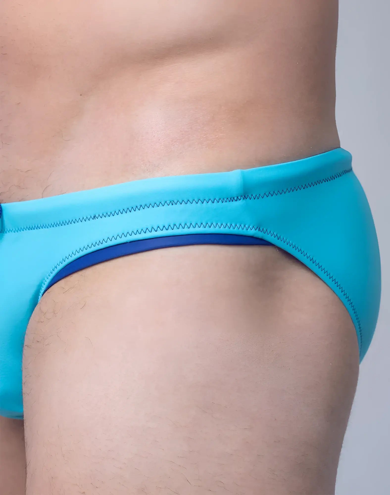 Bright turquoise V22 rapid swim brief with navy blue inner lining and zigzag stitching along the waistband