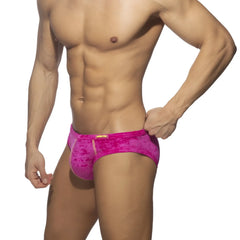 Vibrant pink velvet textured velvet shady bikini brief with subtle pattern and orange brand tag for men