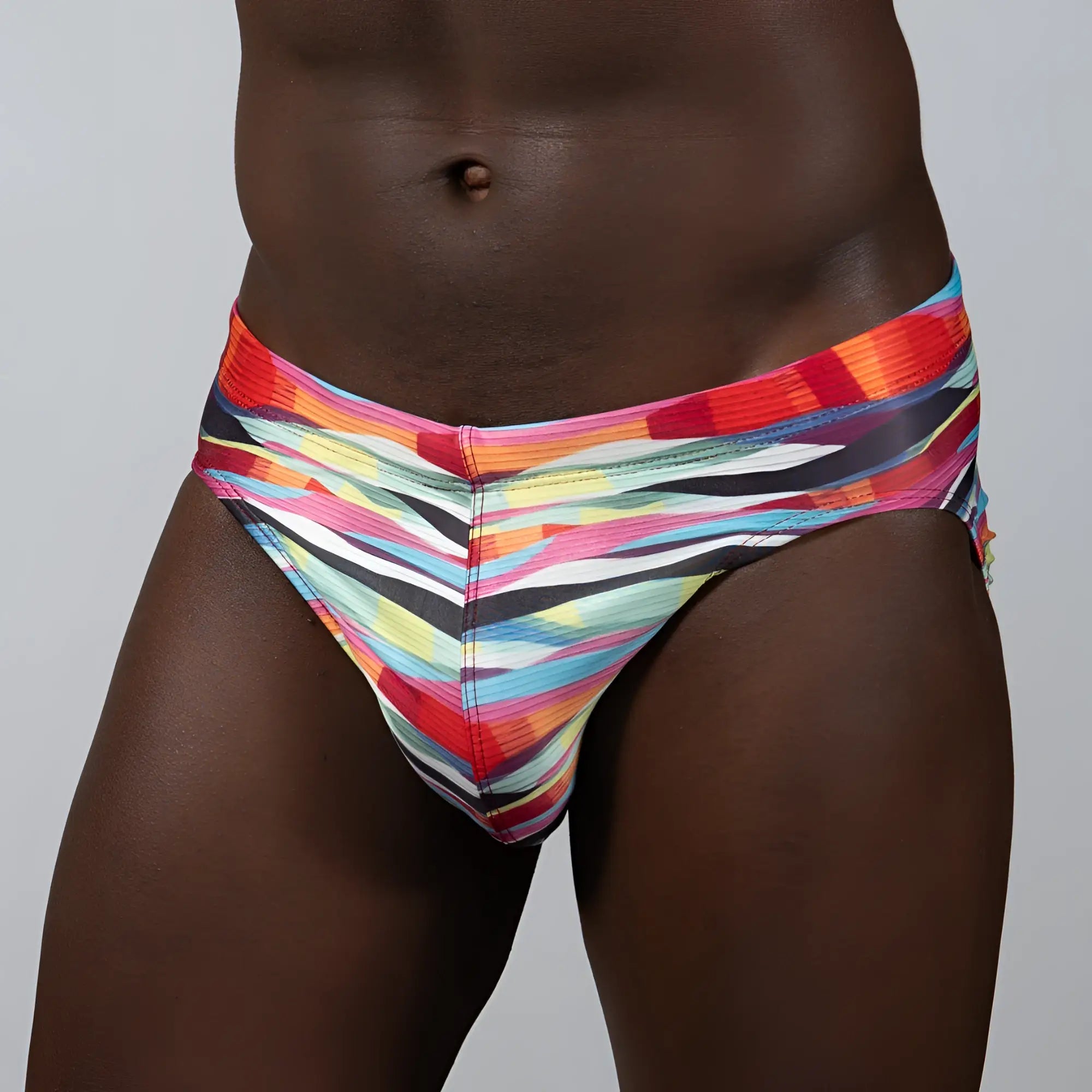 Waves print brief vibrant multicolored swim trunks with bold diagonal red orange yellow blue and black stripes