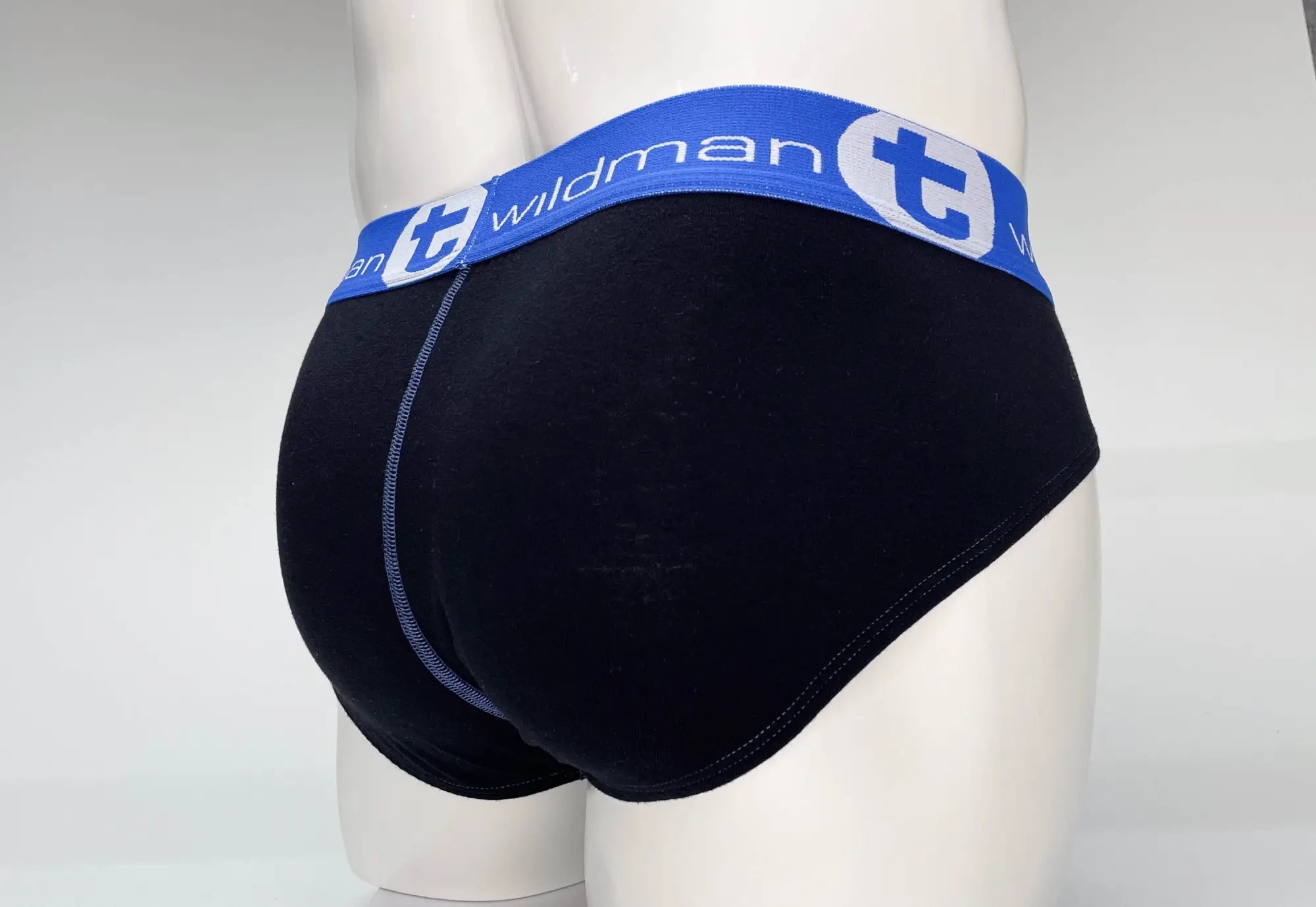 Black cotton briefs with blue elastic waistband featuring wildman logo and white lettering in big boy pouch style