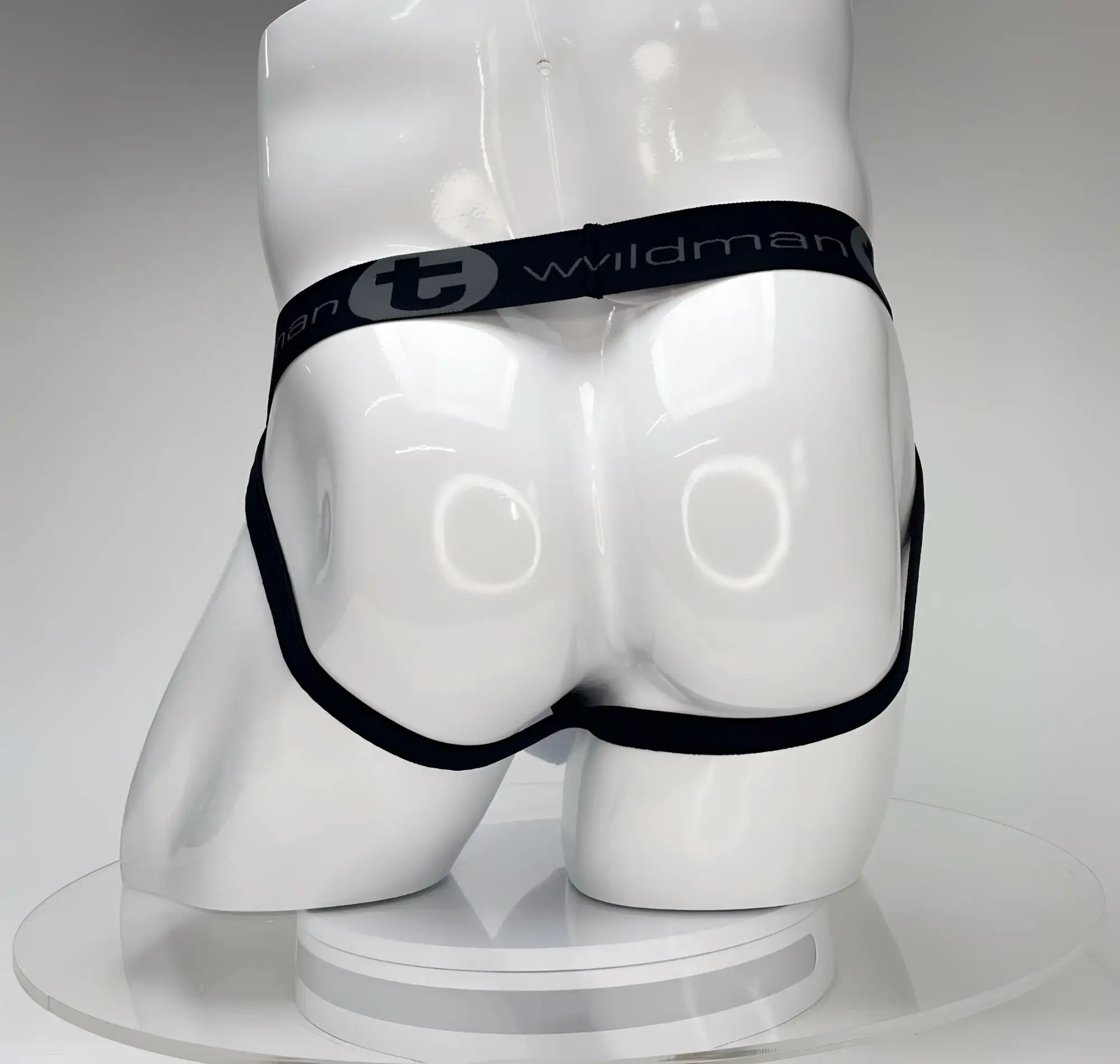 Black elastic waistband with wildman branding on a white wildmant big boy pouch jockstrap displayed on a mannequin