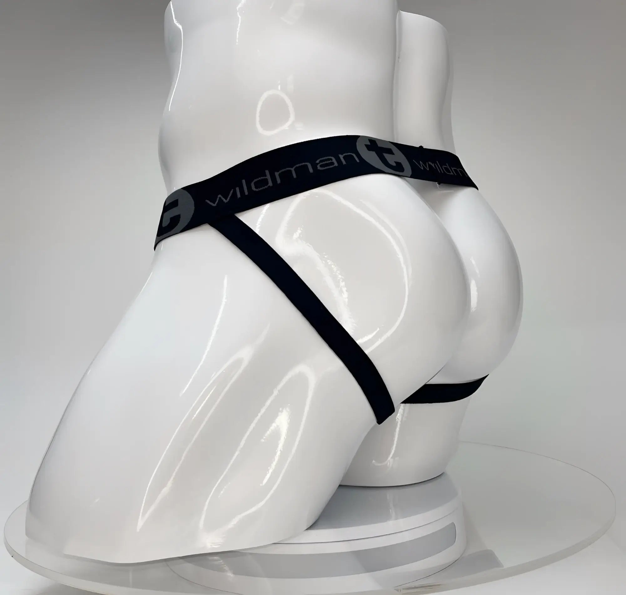 Black elastic waistband with wildman branding on a white mannequin showing the wildmant big boy pouch jockstrap white