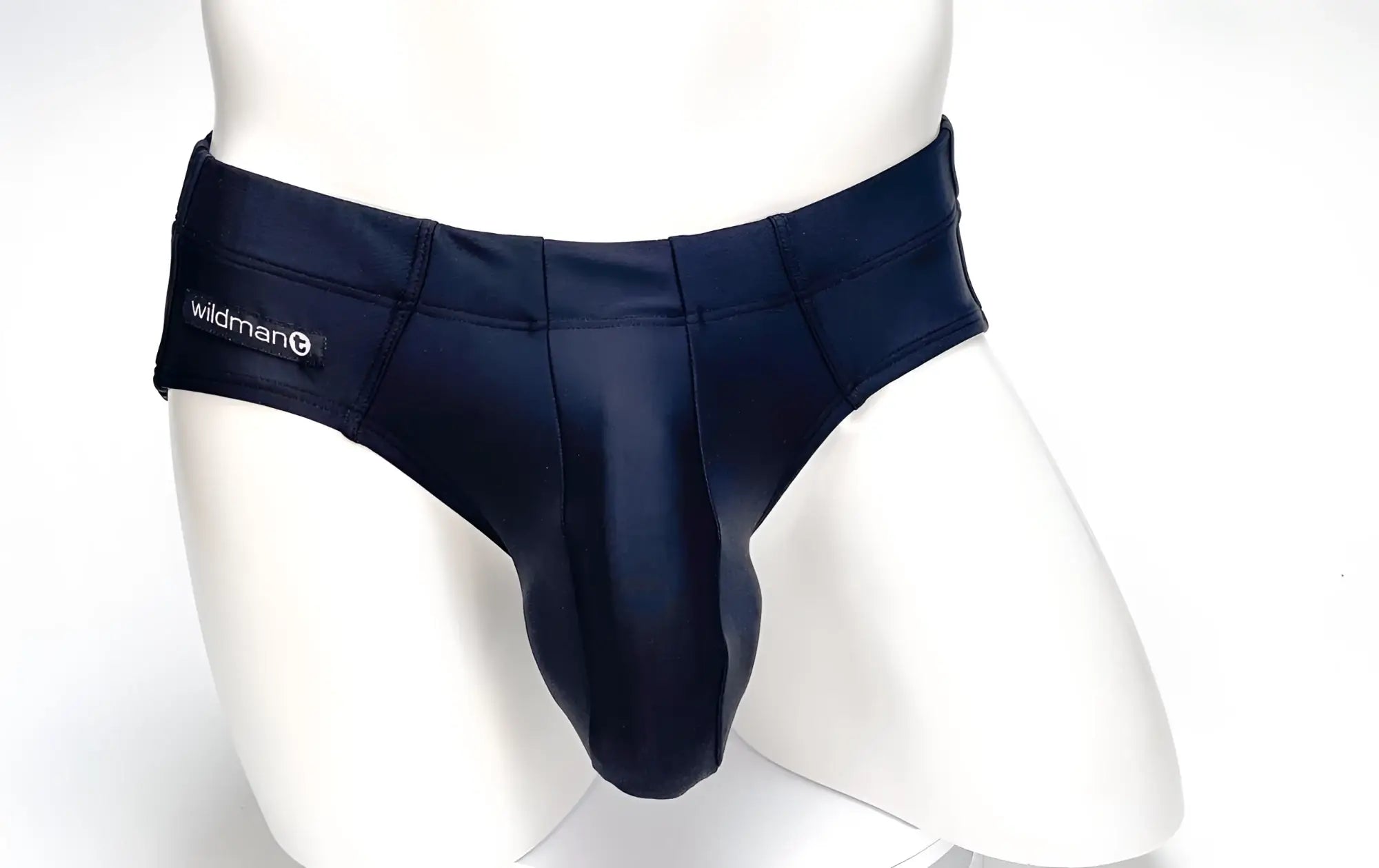 Navy blue synthetic fabric wildmanT big boy pouch swim brief with central seam and logo on left waistband