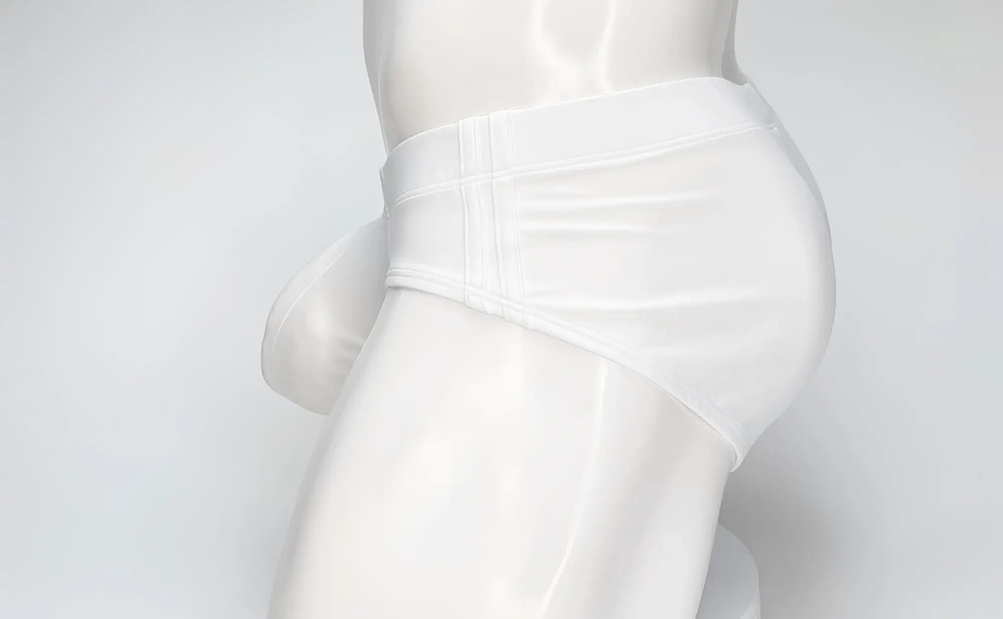WildmanT big boy pouch swim brief in white with smooth glossy fabric and subtle vertical stitching on the waistband