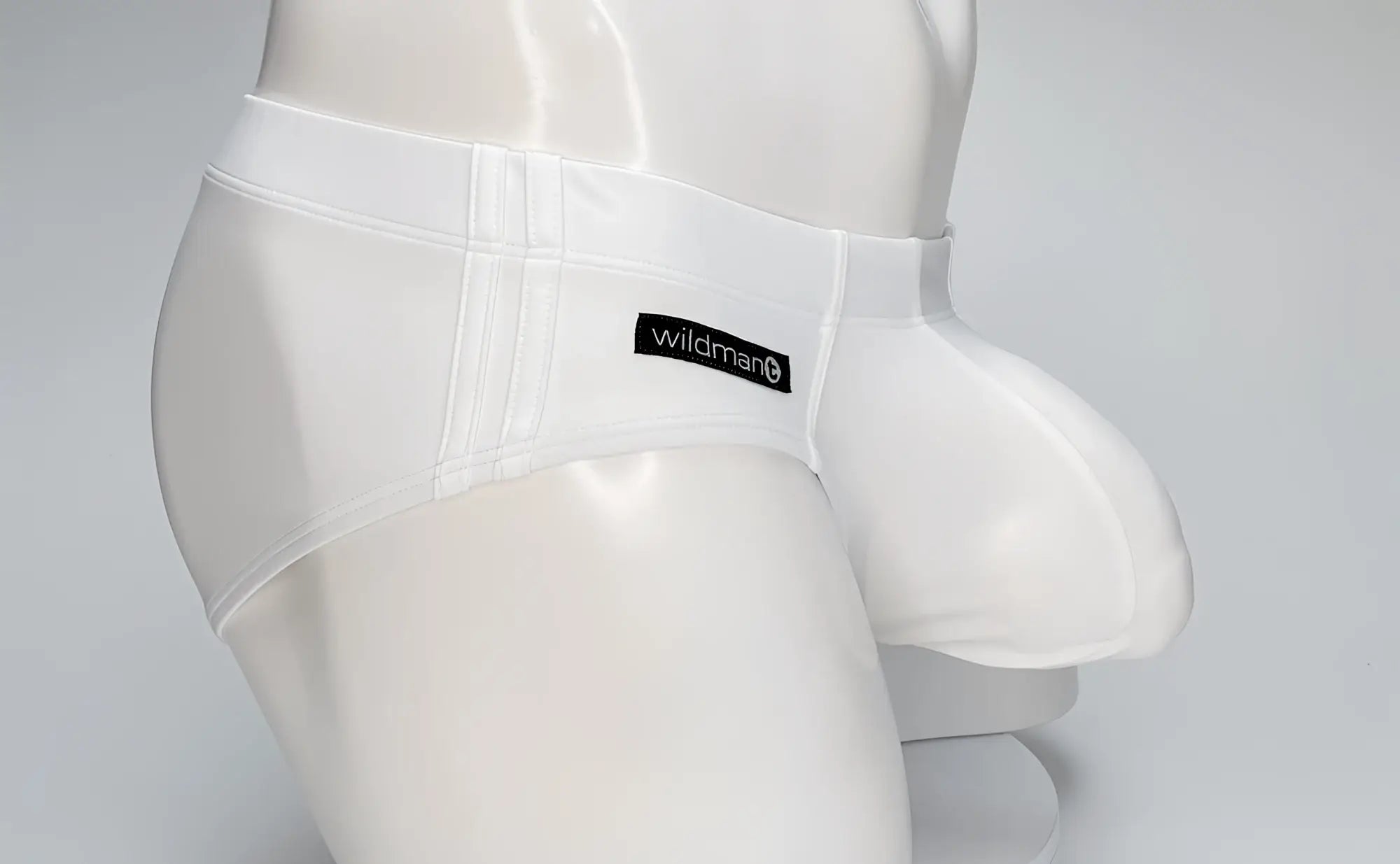 White wildman brand men’s swim brief with a smooth glossy fabric and supportive big boy pouch design