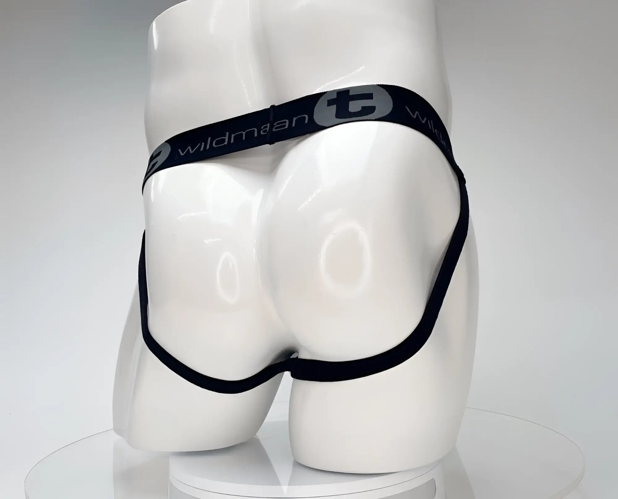 Black elastic waistband with wildman branding on a white mannequin showing the wildmant cotton monster cock jockstrap white