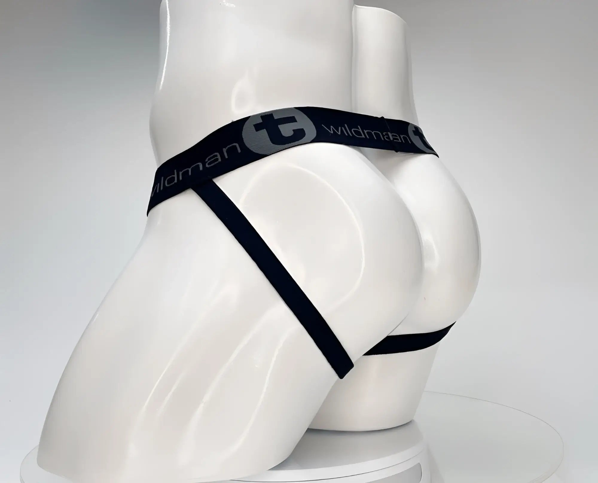 Black elastic waistband with wildman branding on white cotton monster cock jockstrap displayed on mannequin