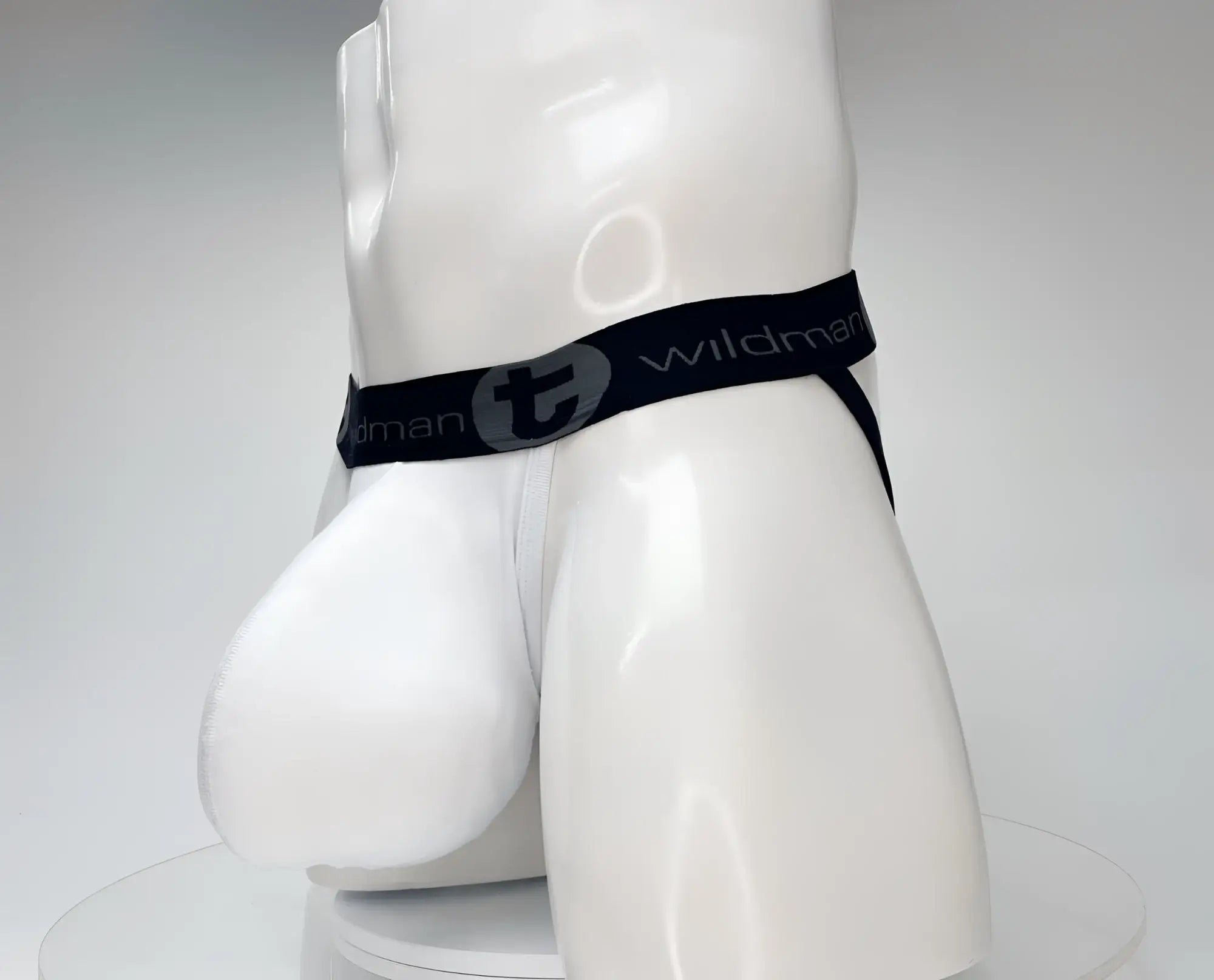 White wildman brand cotton briefs with black elastic waistband and gray logo lettering wildmant cotton monster cock jockstrap white