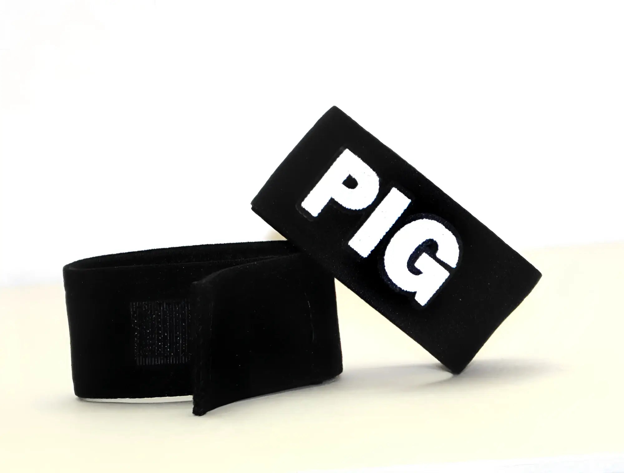 Black fabric wristband with white embroidered pig lettering by wildmant fetish max cock ring pig accessory