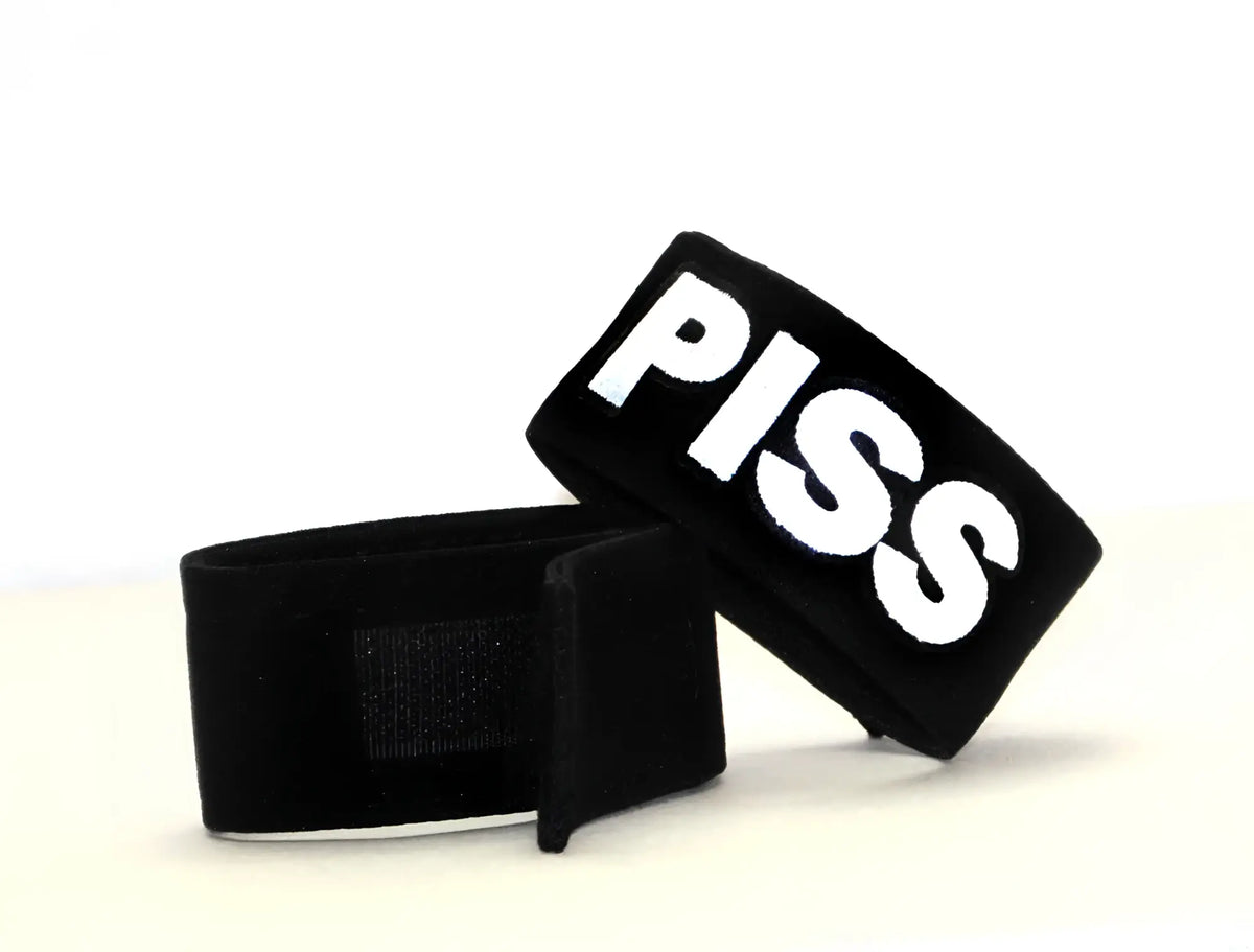 Black wristband cock ring with bold white embroidered piss lettering from WildmanT Fetish Max collection