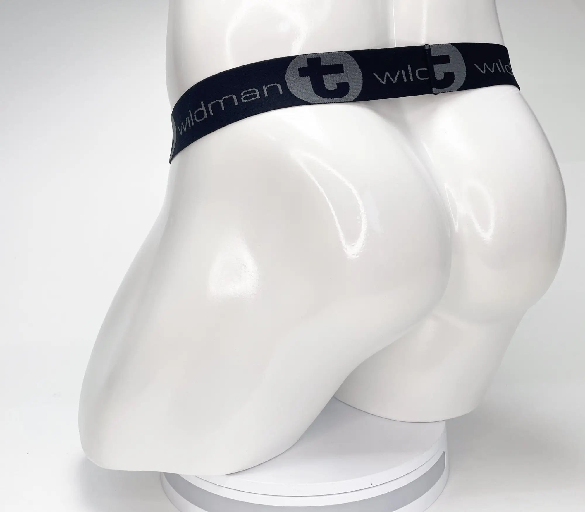 Black elastic waistband with wildman branding on a white mannequin for the wildmant mesh monster cock strapless pouch black